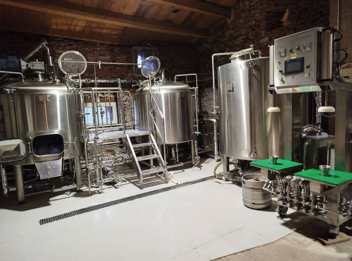 Salle de brassage de la Brasserie des Ruffes — cuves inox dans une cave en pierre au Lac du Salagou